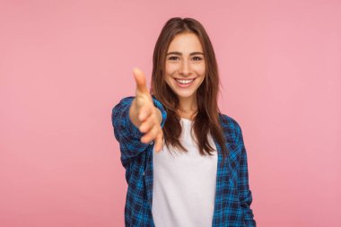 Kareli tişörtlü çekici bir kızın portresi kameraya uzanıyor, el sıkışma ve gülümseme teklif ediyor, iş görüşmesinde öğrenci selamı veriyor. Pembe arka planda kapalı stüdyo çekimleri