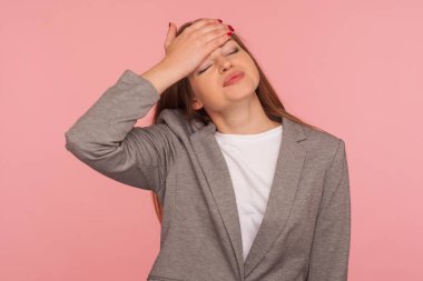 Yüz bakımı. Alnına hüzünlü bir ifadeyle dokunan takım elbiseli, unutkan, üzgün genç bir kadının portresi başarısızlıktan ve kötü hafızadan sorumlu tutuluyor. Pembe arka planda kapalı stüdyo çekimleri