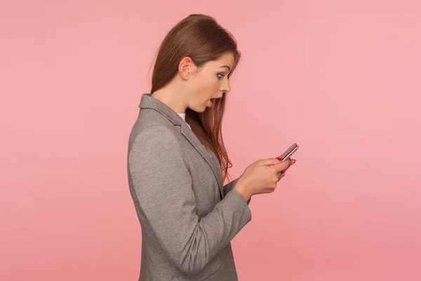 スマートフォンで信じられないほど衝撃的なニュースをチェックし モバイルビジネスアプリケーションを使用して メッセージを読みながら驚きを表現スーツの驚きのエレガントな女性の上司の側面図 スタジオショット分離 — ストック写真