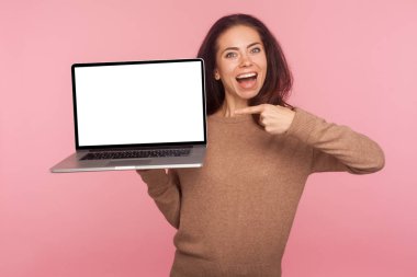 Dizüstü bilgisayarı beyaz ekran fotokopi alanı ile gösteren hayret dolu bir kadının portresi, internet reklamları için maket yap, çevrimiçi servis tarafından şaşırt, şok olduğunu ifade et. Kapalı stüdyo çekimi, pembe arkaplan