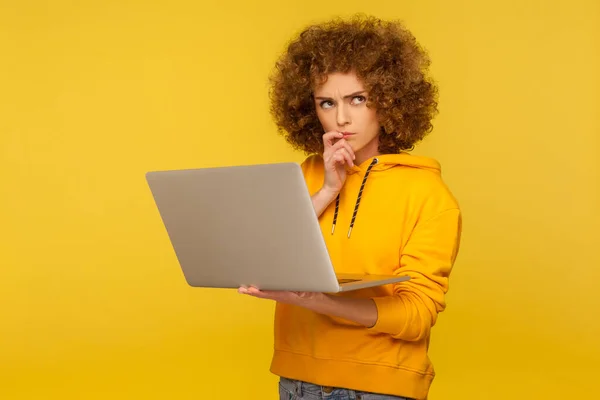 혼란에 사려깊고 곱슬곱슬 스타일의 머리를 여자가 어려운 질문에 노트북을 생각을 — 스톡 사진