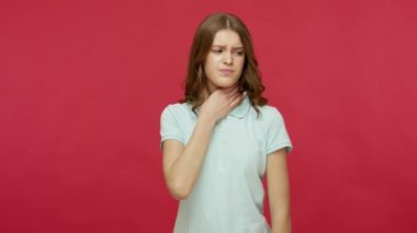 Grip hastası, polo tişörtlü, boynuna dokunan, boğazı ağrıyan, gırtlak iltihabı olan, solunum enfeksiyonu olan, tiroid bozukluğu olan sağlıksız bir genç kadın. Kırmızı arkaplanda izole edilmiş kapalı stüdyo çekimi