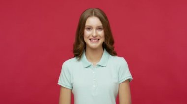 Susun, susun! Polo tişörtlü, mutlu, esmer bir kadın sessiz bir jest yapıyor, parmakları dudaklarında susuyor, sessizlik ya da gizlilik istiyor. Kırmızı arkaplanda izole edilmiş kapalı stüdyo çekimi