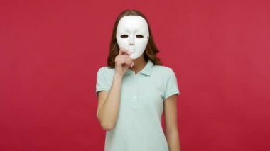 Sahtekar, iletişimdeki ikiyüzlülük. Polo tişörtlü esmer kadın yüz maskesini çıkarıyor ve çeşitli duyguları ifade ediyor. Sürpriz, neşe, üzüntü, öfke gibi. Stüdyo çekimi kırmızı arkaplanda izole edildi