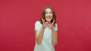 Hey, sana ihtiyacımız var! Polo tişörtlü mutlu esmer kadın kamerayı işaret ediyor, yön gösteriyor, fark ediyor ve şanslı kazananı seçiyor. Kırmızı arkaplanda izole edilmiş kapalı stüdyo çekimi