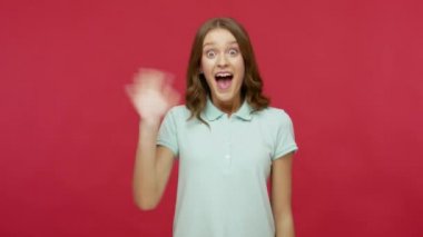 Polo tişörtlü son derece arkadaş canlısı genç esmer kadın el sallıyor ve merhaba diye bağırıyor, hoş geldin jesti ile karşılıyor, tanıştığımıza memnun ve iletişim kurmaya istekli. Stüdyo çekimi kırmızı arkaplanda izole edildi