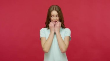 Polo tişörtlü endişeli genç bir kadın anksiyeteden tırnak yiyor, sorunlar konusunda gergin, obsesif kompulsif bozukluk belirtileri, depresyon. Kırmızı arkaplanda izole edilmiş kapalı stüdyo çekimi