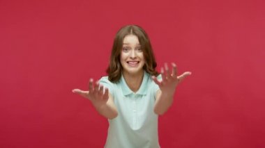 Gel kollarıma! Polo tişörtlü, arkadaş canlısı genç bir kadın. Bedava sarılma, görünmez halat çekme ve kendini kucaklama. Sevgi ve özen gösterme. Stüdyo içi çekim, kırmızı arkaplan