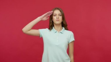 Evet, efendim! Disiplinli, polo tişörtlü, kendine güvenen bir ifadeyle düzeni dinleyen saygı ve itaat eden bir kadın. Kırmızı arkaplanda izole edilmiş kapalı stüdyo çekimi