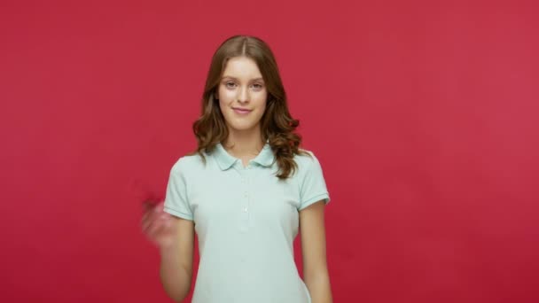 商店打折和购物 穿着马球T恤的年轻而积极的女人指着销售题词微笑着举起大拇指 推荐低价商品 在红色背景下隔离的工作室拍摄 — 图库视频影像