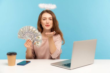 Nimbus 'u olan güzel melek gibi bir kadın dizüstü bilgisayarda oturuyor, elinde dolar banknotları tutuyor ve kameraya şehvetli bir öpücük yolluyor, piyangoda kazanılan parayı gösteriyor. Kapalı alan stüdyo görüntüleri izole, mavi arkaplan