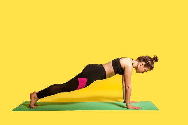 Höhere Plankenpositionen Schlankes Mädchen Mit Haarschopf Enger Sportbekleidung Praktiziert Yoga — Stockfoto