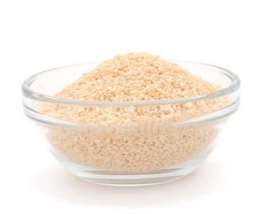 Beyaz arka planda izole edilmiş cam kasedeki susam tohumları. 