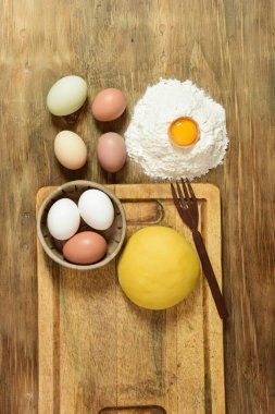 Yumurtalı makarna hamurlu çörek, masada malzemeler var..