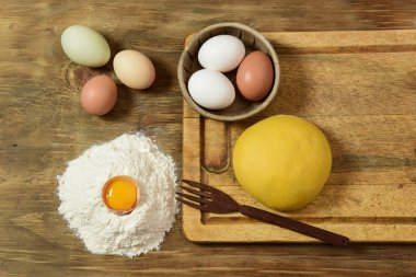 Yumurtalı makarna hamurlu çörek, masada malzemeler var..