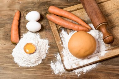 Portakallı havuçlu erişte hamuru ve masada malzemeler..