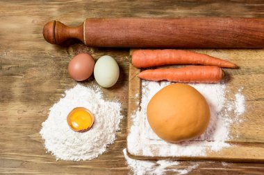 Portakallı havuçlu erişte hamuru ve masada malzemeler..