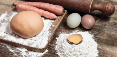Portakallı havuçlu erişte hamuru ve masada malzemeler..