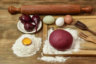 Masadaki malzemeli erişteler için mor hamur çöreği..