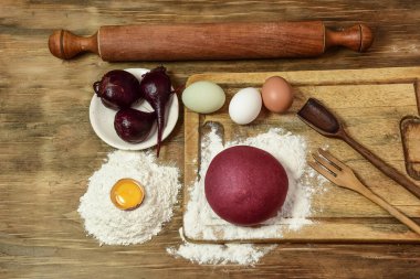 Masadaki malzemeli erişteler için mor hamur çöreği..