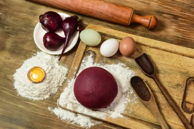 Masadaki malzemeli erişteler için mor hamur çöreği..