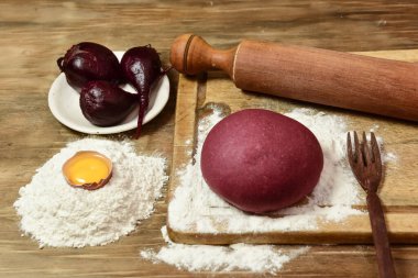 Masadaki malzemeli erişteler için mor hamur çöreği..