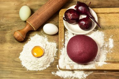 Masadaki malzemeli erişteler için mor hamur çöreği..