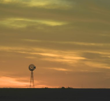Gün batımında yel değirmeni, Pampas, Patagonya, Arjantin.