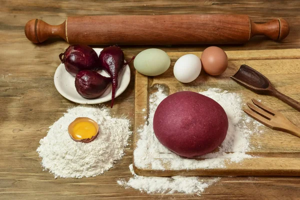 Masadaki malzemeli erişteler için mor hamur çöreği..