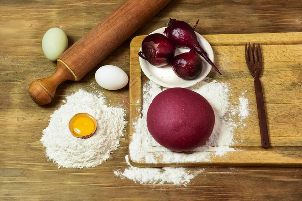 Masadaki malzemeli erişteler için mor hamur çöreği..