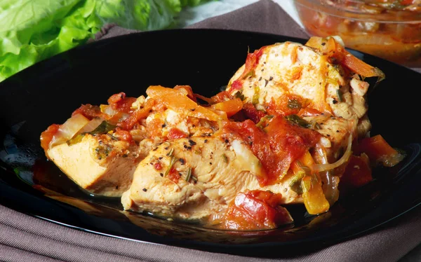 Sebzeli tavuk, siyah tabakta akşam yemeği.