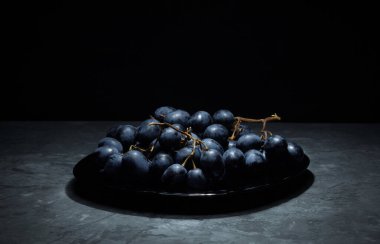 Siyah üzümlü bir tepside bir demet üzüm