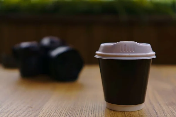 Takeaway coffee cup with camera blurred in background
