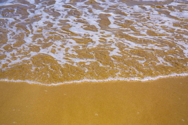 Köpüklü deniz suyuyla altın rengi kum — Stok fotoğraf