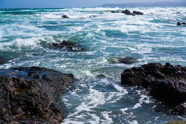 Golven op rotsachtig strand — Stockfoto