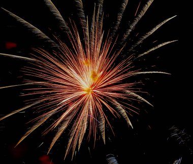 Koyu gökyüzünde kırmızı renkli havai fişekler patlıyor