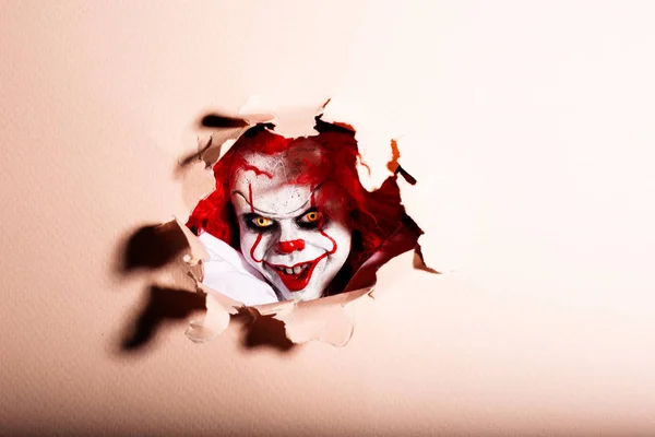 Uno spaventoso clown killer sfonda il muro. Orrore. Halloween co — Foto Stock