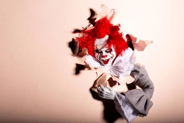 Przerażający zabójca klaunów przebija się przez ścianę. przerażenie. Halloween co — Zdjęcie stockowe