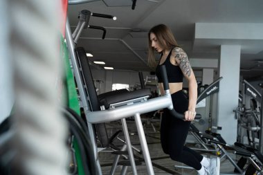 Ternopil, Ukrayna - 8 Şubat 2020. Atletik genç vücut geliştirici kadın, spor salonu, ağırlık antrenmanı, kas, dövmeli, kardiyo sporu eğitimi yaşam tarzı konsepti geçmişi, 