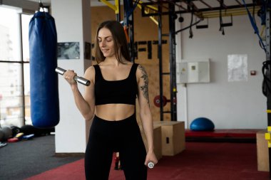 Ternopil, Ukrayna - 8 Şubat 2020. Atletik genç vücut geliştirici kadın, spor salonu, ağırlık antrenmanı, kas, dövmeli, kardiyo sporu eğitimi yaşam tarzı konsepti geçmişi, 