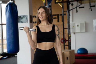 Ternopil, Ukrayna - 8 Şubat 2020. Atletik genç vücut geliştirici kadın, spor salonu, ağırlık antrenmanı, kas, dövmeli, kardiyo sporu eğitimi yaşam tarzı konsepti geçmişi, 