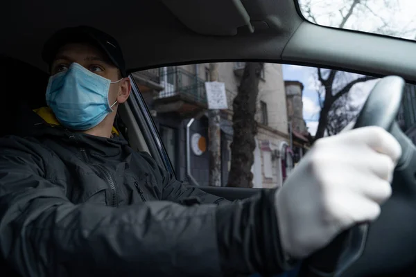 NEW YORK, ABD - 1 Nisan 2019: Adam karantina sırasında arabada, güvenlik için koruyucu maske ve eldiven takıyor.