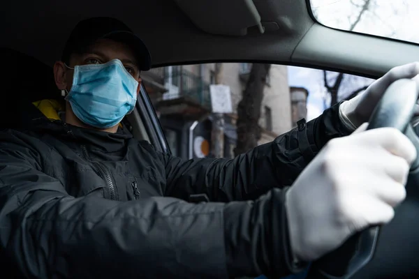 NEW YORK, ABD - 1 Nisan 2019: Adam karantina sırasında arabada, güvenlik için koruyucu maske ve eldiven takıyor.