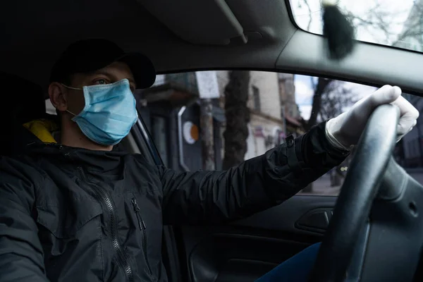 NEW YORK, ABD - 1 Nisan 2019: Adam karantina sırasında arabada, güvenlik için koruyucu maske ve eldiven takıyor.