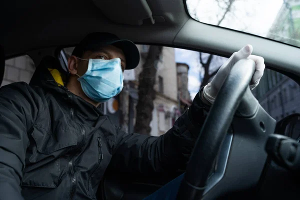 NEW YORK, ABD - 1 Nisan 2019: Adam karantina sırasında arabada, güvenlik için koruyucu maske ve eldiven takıyor.