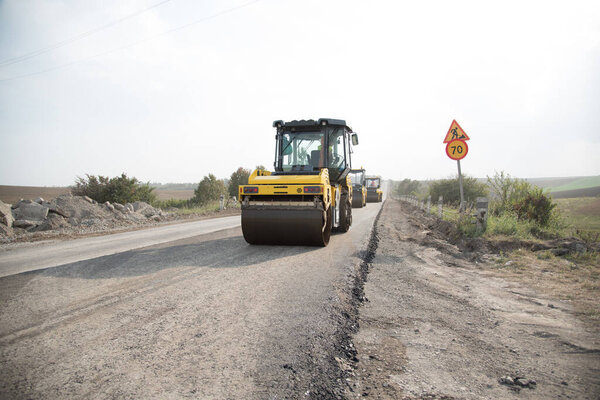 asphalt roller, rolls up a new road. road construction