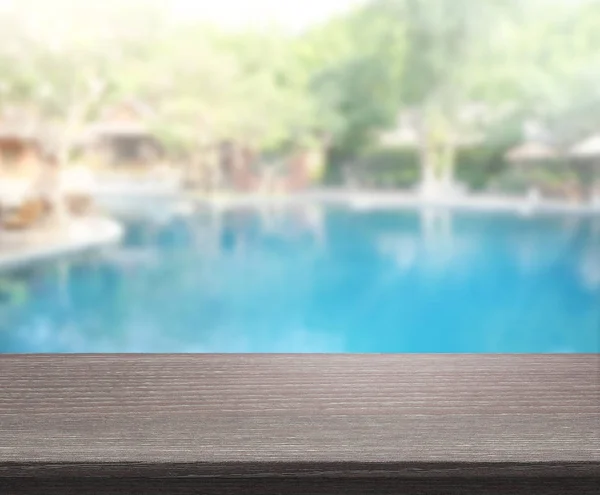 Tischplatte und Swimmingpool im Hintergrund verschwimmen — Stockfoto