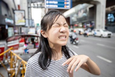 Asian child girl with a burning sensation,eye irritation from car smoke in the city,feel eyes pain,dust,ocular allergy with closed eyes effect of air pollution,teenage on street in toxic environments  clipart
