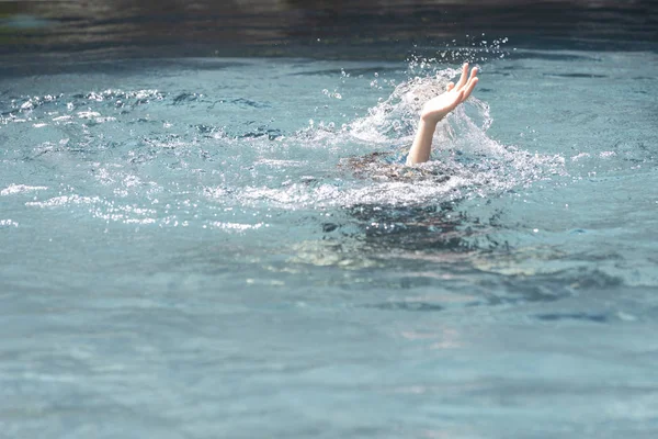 Ασιατικό κορίτσι παιδί παλεύει κάτω από το νερό, χέρι κρυφοκοιτάζει έξω από το — Φωτογραφία Αρχείου