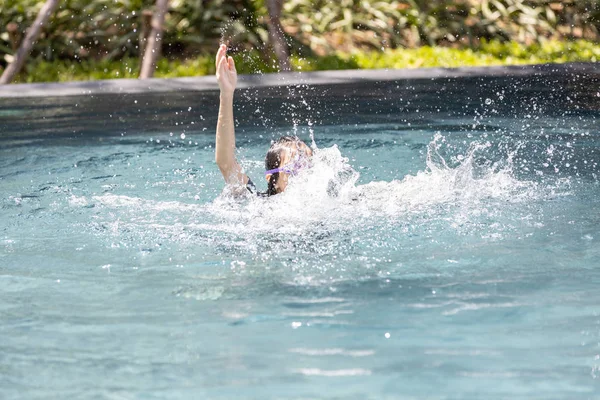 Asian child girl struggling underwater, hand peeking out of the water, female drowned in swimming pool, drowning woman in swimming pool asking for help in dangerous situation